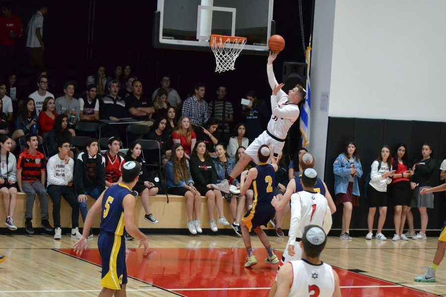 EFFORT%3A+Shalhevet%27s+Sammy+Ellenhorn+leaps+over+TABC+defense+in+Game+4+Nov.+10.+The+Firehawks+won%2C+44-42.