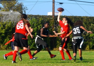 OVERHEAD: Quarterback Nicole Feder evades a sack as she quickly throws the ball Sept. 22 against the LA Adventist Eagles